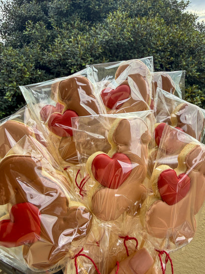 Bouquet of cookies shaped like hearts and bunnies in clear packaging outdoors.