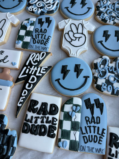 Decorative cookies with 'Rad Little Dude' text and graphics on a white surface