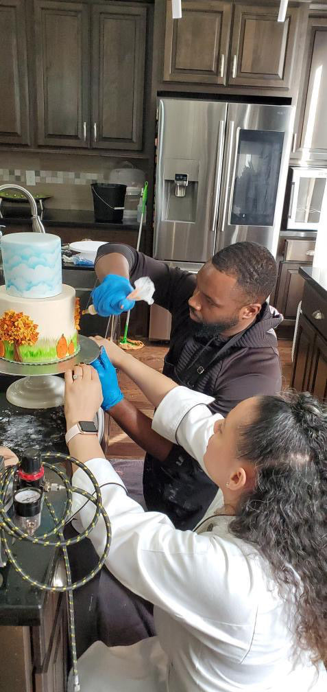 Chef Erica showing a student how to pipe icing directly onto a cake